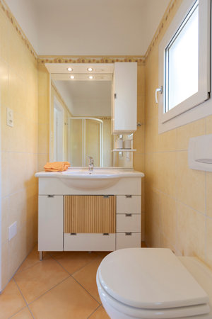 Front view of the bathroom cabinet with sink, mirror and soap. Behind it is the shower. No one insideの写真素材