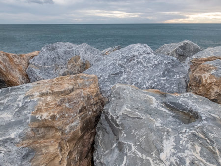 Sunrise and horizon with stones in foreground, Italyの写真素材