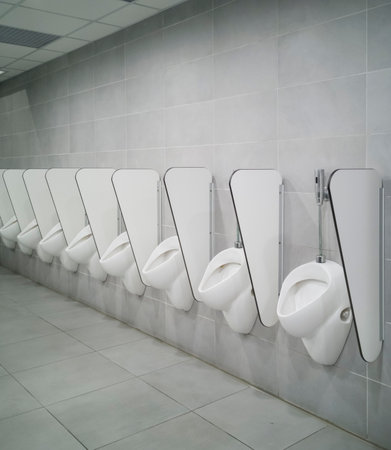 Long line of male pissers. No one uses them, new and modern space.の写真素材