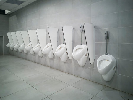Long line of male pissers. No one uses them, new and modern space.の写真素材