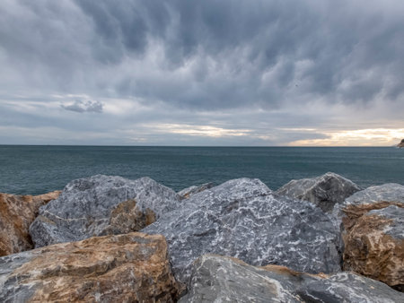 Sunrise and horizon with stones in foreground, Italyの写真素材