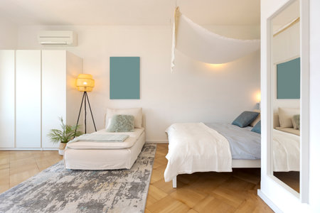 Studio apartment with one double bed and one single bed. There is also parquet flooring, a lamp and a nice canopy. front viewの写真素材