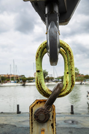 Detail of a hook attached to a construction crane in a port in Italy. Cloudy sky. No one insideの写真素材