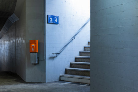 Detail of a staircase in a train station with the orange ticket validation machine next to it. No one insideの写真素材