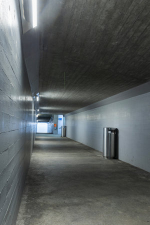 Long concrete pedestrian corridor that passes under the train station in Melide in Switzerland....