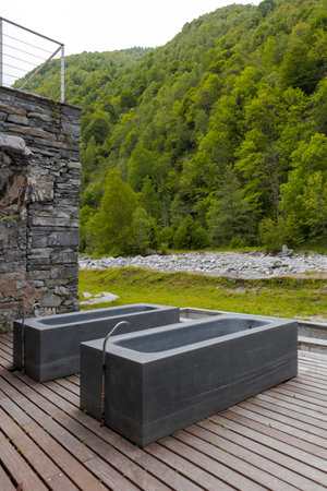 Thermal bath tubs with a view of the river and Swiss nature. Nobody inside, frontal viewの写真素材