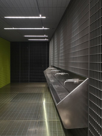 Modern washhouse of public toilets underground. Space designed with grids. No one insideの写真素材
