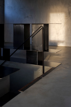 Detail of a stairway with metal railing and a contemporary bookshelf. There is a light at sunset. There's no one inside.の写真素材