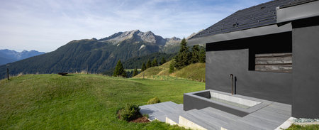 Modern mountain chalet in the midst of nature with stunningly beautiful views. You can see green meadows and mountains. Ideal for a banner. Space to write a textの写真素材