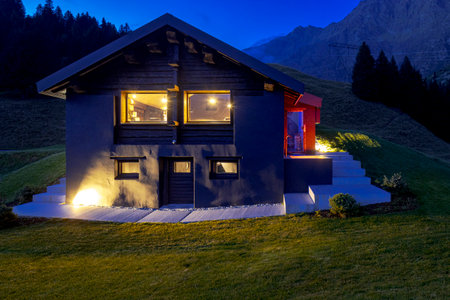 Modern mountain chalet in the middle of the evening as the sun sets and the night rises. Beautiful and evocative colours. Romance guaranteed. The place is the south of Switzerlandの写真素材