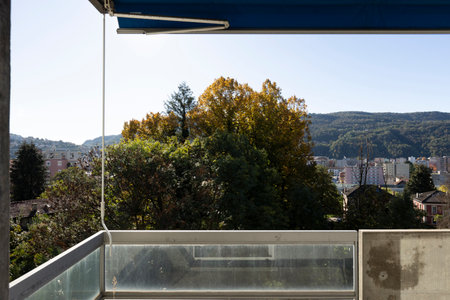 View from a balcony, green trees and green mountains in the background. Sunny winter day. No one inside.の写真素材