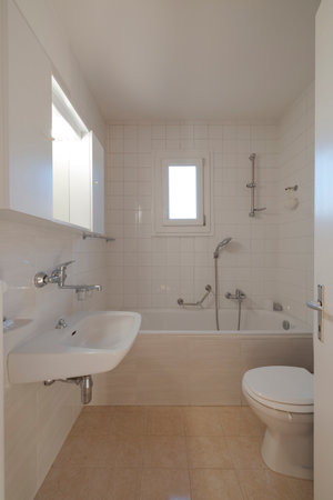 Interior of a bathroom in a small city flat. The toilet, sink and bathtub can be seenの写真素材
