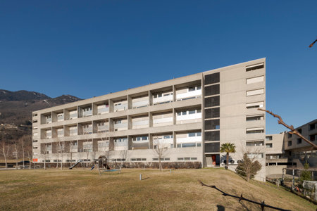 Popular condominium with a large garden with slides for children and other games in front. The sky is blue and there is no one inside.の写真素材