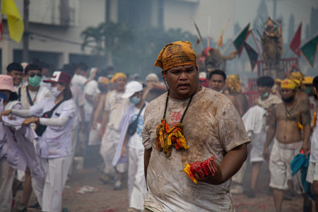 group of men march in the middle of firecrackers and smoke at a vegetarian festival, Phuket,...