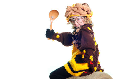 The girl with the big spoon sits on a flankの写真素材