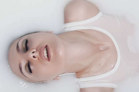 Pretty woman using fresh water in the bath roomの写真素材