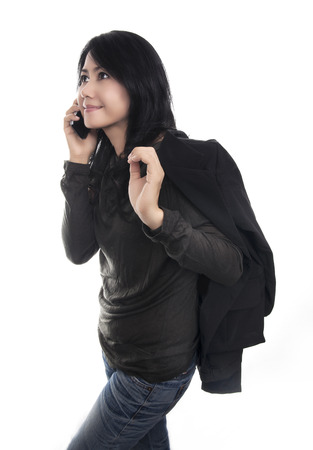 Happy woman phone talking, isolated on white background  -Beautiful asian woman in black shirt, jacket and blue jean の写真素材