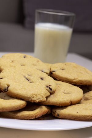 Chocolate chip cookies perspective close up. with a glass of milk on the backgroundの写真素材