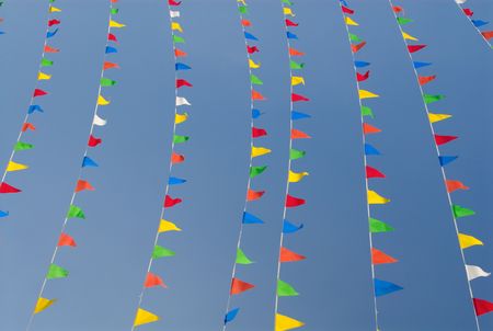 Strings of Colorful Bunting flags against blue sky.の写真素材