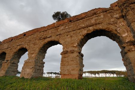 ancient roman aqueduct, more than two thousand years old standing against grey sky rome italyの写真素材
