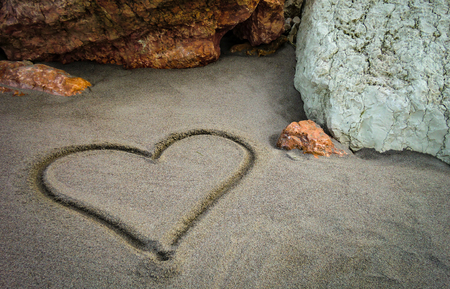 A heart drawn on the sand of the unspoiled beach: a gesture of sweet and poetic love for those who truly loveの写真素材