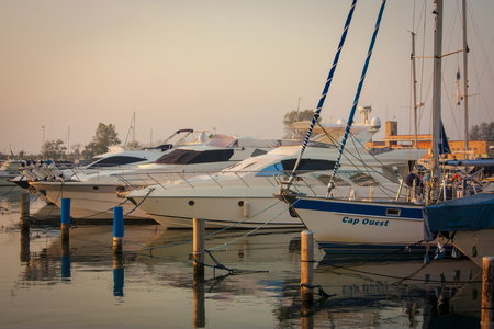 View of several boats moored on the great port of Albarella in Italy, illuminated by the warm colors of dawnの写真素材