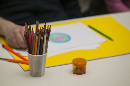 Container full of colorful crayons and blurred background a person drawing in a drawing school.の写真素材