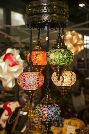 Large chandelier consisting of various handmade inlaid colored glass lamppads: A handcrafted oriental vintage object.の写真素材