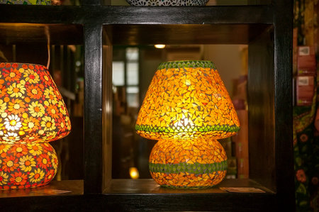 Lamp made of yellow glass pieces for a hot lizard, leaning on a dark wooden bookcase: tastefully decorated.の写真素材