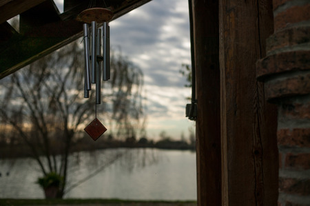 Metal hooks and wood hanging outside with a magnificent sunset behindの写真素材