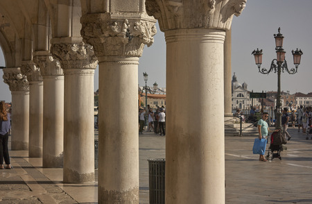 Columns of the arcades of piazza san marco in venezia illuminated by a hot summer sun.の写真素材