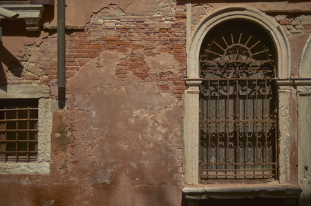 Window with grates belonging to an old decadent building ruined by timeの写真素材