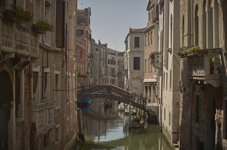 Two rows of houses and buildings in Venice kept separated by a small stream of boats and bridges.の写真素材