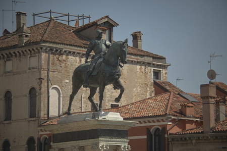 Statue or monument of a knight in bronze horse, surrounded by palaces and historic houses in italy.の写真素材