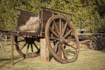 Old and worn vintage wooden carriage used as a decor element inside a countryside garden.の写真素材