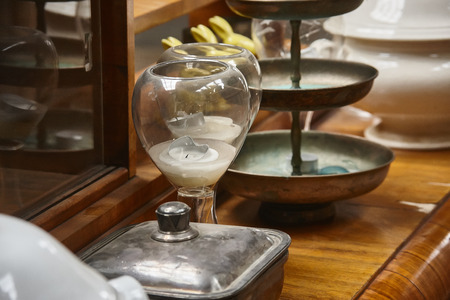 Still life with various vintage objects resting on top of a historic piece of furniture: Glasses, metal boxes and objects for decorative use.の写真素材