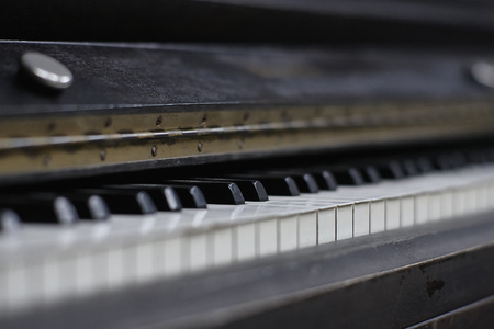 Ivory keys of an antique piano with the signs of time and wear gone by.の写真素材