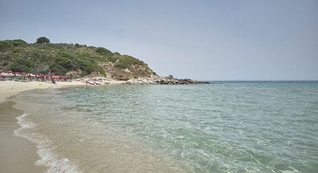 Typical Sardinian beach (Cala Sinzias) with crystal clear sea and the vegetation of the mountains overlooking the sea.の写真素材