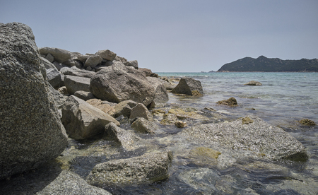 Detail of the crystalline water of the sea that crashes against the natural rocks at the shore.の写真素材