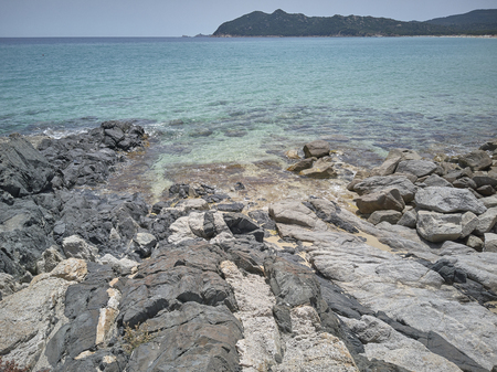 Wide-angle shot of some rocks that join the crystalline sea of southern Sardinia.の写真素材