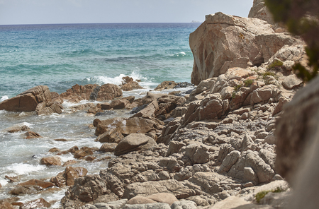 Detail of some rocks emerging from the sea in a rocky Mediterranean beach.の写真素材