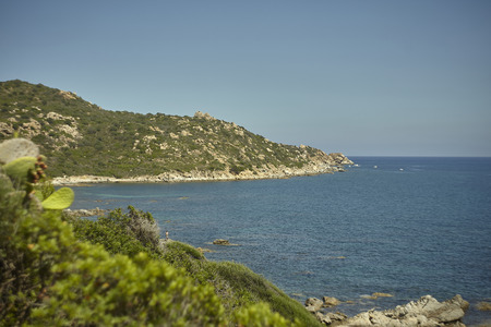 Natural inlet between the mountains and the sea in the south of Sardinia with the outline of a typical Mediterranean vegetation that grows spontaneously on the rocky walls.の写真素材
