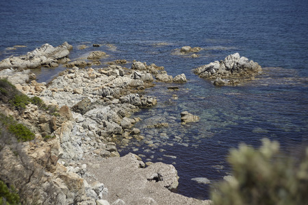 Some rocks that develop from the coast to the water of the sea merging into one thing.の写真素材