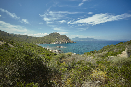 Panorama of a natural bay in the south of Sardinia in Italy with the mountains overlooking the sea in broad daylight during the summer.の写真素材