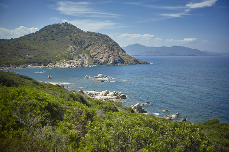 Natural inlet between the mountains and the sea in the south of Sardinia with the outline of a typical Mediterranean vegetation that grows spontaneously on the rocky walls.の写真素材