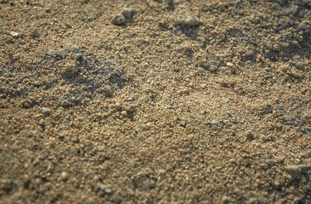 Texture of fine Mediterranean sand with some pebbles shot during the sunset.の写真素材
