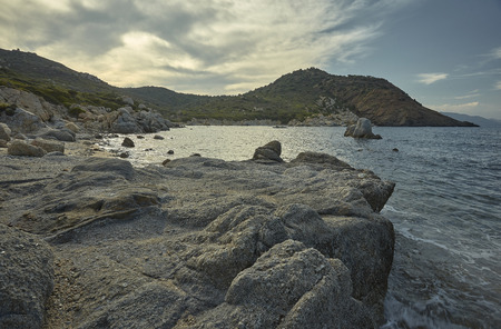 Beautiful Mediterranean beach typical of the coast of southern Sardinia taken over in summer. The beach, the rocks and the mountains behind blend in a wonderful panorama of amazing beauty.の写真素材
