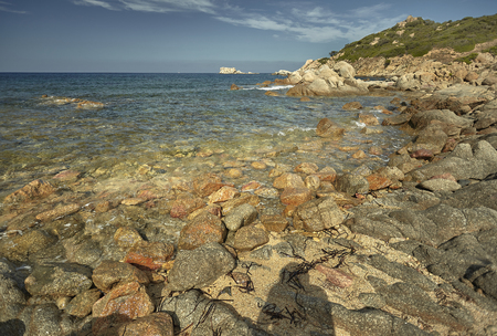 stones coming out of the sea where the sea meets the land at the shore.の写真素材