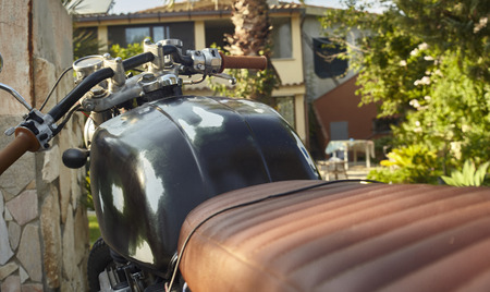 First hand view of the driving position of a vintage motorcycle stripped down and worn by time and numerous journeys.の写真素材