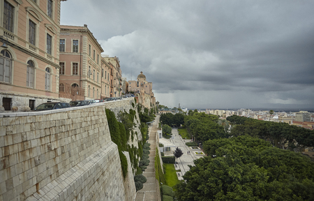 View of the main historical buildings of the historic center of Cagliari in Sardinia under a cloudy sky.の写真素材